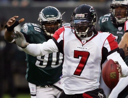 PHILADELPHIA - DECEMBER 31:  (FILE) Michael Vick #7 of the Atlanta Falcons scrambles under pressure from Darren Howard #90 of the Philadelphia Eagles in NFL action December 31, 2006 at Lincoln Financial Field in Philadelphia, Pennsylvania. According to reports on August 13, 2009, the Philadelphia Eagles have signed Vick to a two-year contract.  <br /><br /><span class="help">(Photo by Jim McIsaac/Getty Images)</span>