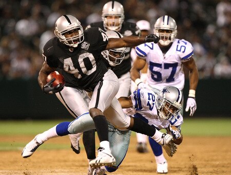 OAKLAND, CA - AUGUST 13:  Louis Rankin #40 of the Oakland Raidersl runs against Courtney Brown #27 of the Dallas Cowboys during a preseason game at Oakland-Alameda County Coliseum on August 13, 2009 in Oakland, California.  <br /><br /><span class="help">(Photo by Jed Jacobsohn/Getty Images)</span>