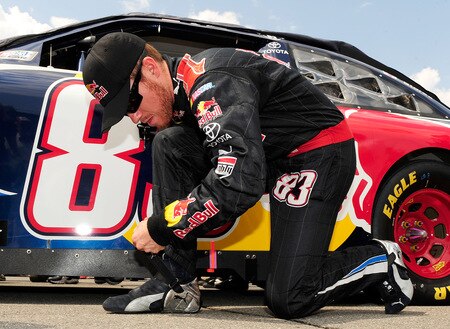 BROOKLYN, MI - AUGUST 16:  Brian Vickers, driver of the #83 Red Bull Toyota, adjusts his shoes as he kneels on the grid during the NASCAR Sprint Cup Series CARFAX 400 at Michigan International Speedway on August 16, 2009 in Brooklyn, Michigan.  <br /><br /><span class="help">(Photo by Rusty Jarrett/Getty Images for NASCAR)</span>