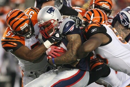FOXBORO, MA - AUGUST 20:  Fred Taylor #21 of the New England Patriots is stopped as he runs the ball by Dhani Jones #57 (L) and Keith Rivers #55 (R) of the Cincinnati Bengals during their preseason game at Gillette Stadium on August 20, 2009 in Foxboro, Massachusetts.  <br /><br /><span class="help">(Photo by Jim Rogash/Getty Images)</span>