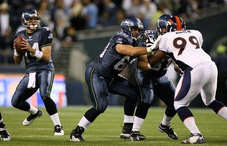 SEATTLE - AUGUST 22:  Max Unger #60 of the Seattle Seahawks pass protects for quarterback Mike Teel #14 against Matthias Askew #99 of the Denver Broncos on August 22, 2009 at Qwest Field in Seattle, Washington. The Seahawks defeated the Broncos 27-13. <br /><br /><span class="help">(Photo by Otto Greule Jr/Getty Images)</span>