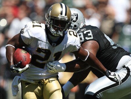 OAKLAND, CA - AUGUST 29: Mike Bell #21 of the New Orleans Saints runs against Tommy Kelly #93 of the Oakland Raiders during an NFL preseason game at Oakland-Alameda County Coliseum on August 29, 2009 in Oakland, California.  <br /><br /><span class="help">(Photo by Jed Jacobsohn/Getty Images)</span>