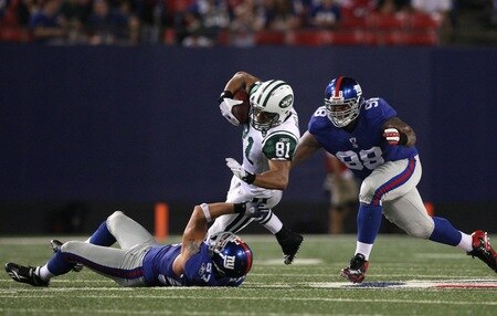EAST RUTHERFORD, NJ - AUGUST 29: Tight end Dustin Keller #81 of the New York Jets gets taken down by linebacker Chase Blackburn #57 and defensive tackle Fred Robbins #98 of the New York Giants during the preseason game at Giants Stadium on August 29, 2009 in East Rutherford, New Jersey.  <br /><br /><span class="help">(Photo by Jim McIsaac/Getty Images)</span>