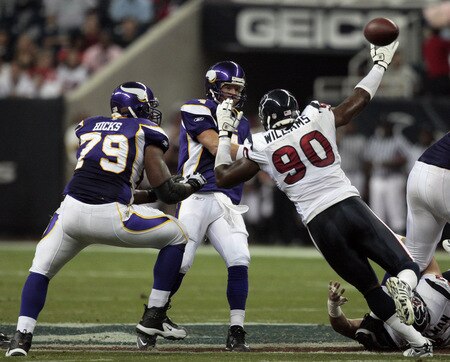 HOUSTON - AUGUST 31:  Quarterback Brett Favre #4 of the Minnestoa Vikings releases the ball as he is pressured by defensive end Mario Williams #90 of the Houston Texans at Reliant Stadium on August 31, 2009 in Houston, Texas.  <br /><br /><span class="help">(Photo by Bob Levey/Getty Images)</span>