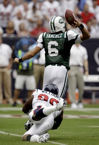HOUSTON - SEPTEMBER 13: Quarterback Mark Sanchez #6 of the New York Jets is tackled from behind by defensive end Mario Williams #90 of the Houston Texans as he releases the ball at Reliant Stadium on September 13, 2009 in Houston, Texas.  <br /><br /><span class="help">(Photo by Bob Levey/Getty Images)</span>