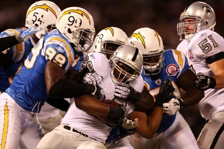 OAKLAND, CA - SEPTEMBER 14: Michael Bush #29 of the Oakland Raiders is tackled by Kevin Burnett #99 the San Diego Chargers along with other CHarger defenders on September 14, 2009 at the Oakland-Alameda County Coliseum in Oakland, California.  <br /><br /><span class="help">(Photo by Ezra Shaw/Getty Images)</span>