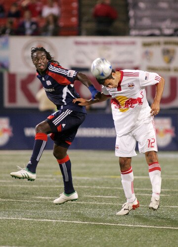 EAST RUTHERFORD, NJ - SEPTEMBER 18: Mike Petke #12 of the New York Red Bulls heads the ball away from Shalrie Joseph #21 of the New England Revolution during their game at Giants Stadium on September 18, 2009 in East Rutherford, New Jersey. The Red Bulls and the Revolution played to a 1-1 tie.  <br /><br /><span class="help">(Photo by Andy Marlin/Getty Images for New York Red Bulls)</span>