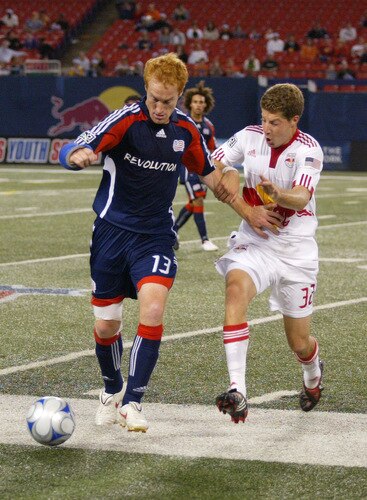 EAST RUTHERFORD, NJ - SEPTEMBER 18: Luke Sassan #32 of the New York Red Bulls and Jeff Larentowicz #13 of the New England Revolution  battle for a loose ball during their game at Giants Stadium on September 18, 2009 in East Rutherford, New Jersey. The Red Bulls and the Revolution played to a 1-1 tie.  <br /><br /><span class="help">(Photo by Andy Marlin/Getty Images for New York Red Bulls)</span>