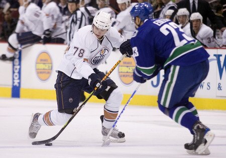 VANCOUVER, CANADA - SEPTEMBER 19: Marc-Antoine Pouliot #78 of the Edmonton Oilers tries to get past Alexander Edler #23 of the Vancouver Canucks during the first period of NHL preseason action on September 19, 2009 at General Motors Place in Vancouver, British Columbia, Canada.  <br /><br /><span class="help">(Photo by Rich Lam/Getty Images)</span>