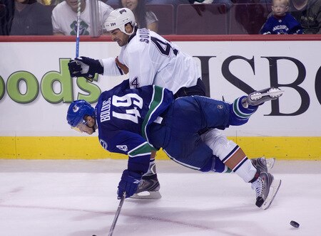 VANCOUVER, CANADA - SEPTEMBER 19: Alexandre Bolduc #49 of the Vancouver Canucks is knocked down to the ice by Sheldon Souray #44 of the Edmonton Oilers during the third period of NHL preseason action on September 19, 2009 at General Motors Place in Vancouver, British Columbia, Canada.  <br /><br /><span class="help">(Photo by Rich Lam/Getty Images)</span>