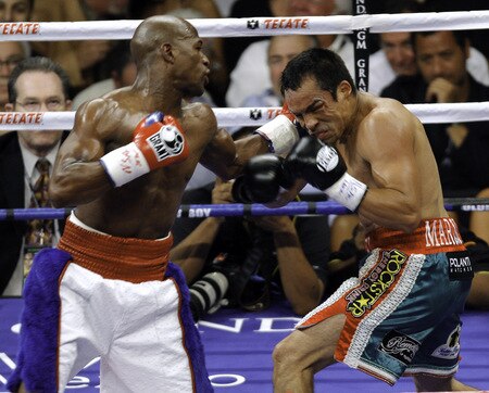 LAS VEGAS - SEPTEMBER 19:  Floyd Mayweather Jr. (L) hits Juan Manuel Marquez during their bout at the MGM Grand Garden Arena September 19, 2009 in Las Vegas, Nevada. Mayweather won by unanimous decision.  <br /><br /><span class="help">(Photo by Eric Jamison/Getty Images)</span>