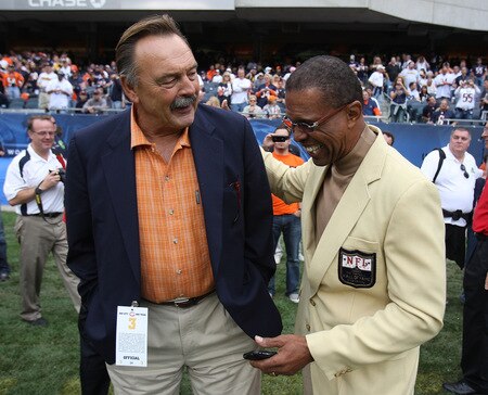 CHICAGO - SEPTEMBER 20: Hall of Fame Chicago Bears Dick Butkus (L) and Gale Sayers share a laugh on the sidelines before a game between the Bears and the Pittsburgh Steelers on September 20, 2009 at Soldier Field in Chicago, Illinois. The Bears defeated the Steelers 17-14. <br /><br /><span class="help">(Photo by Jonathan Daniel/Getty Images)</span>