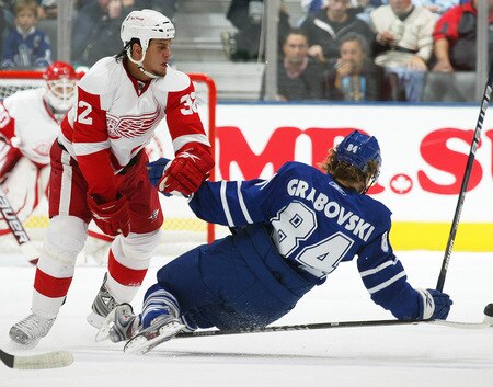 TORONTO, ON - SEPTEMBER 26:   Mikhail Grabovski #84 of the Toronto Maple Leafs takes a big hit from Kris Newbury #32 of the Detroit Red Wings in a pre-season game on September 26, 2009 at the Air Canada Centre in Toronto, Ontario.<br /><br /><span class="help">(Photo by Claus Andersen/Getty Images)</span>