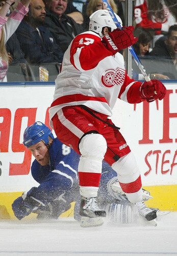 TORONTO, ON - SEPTEMBER 26:  Mike Komisarek #8 of the Toronto Maple Leafs takes a hit from Patrick Eaves #17 of the Detroit Red Wings in a pre-season game on September 26, 2009 at the Air Canada Centre in Toronto, Ontario. The Leafs defeated the Red Wings 2-1. <br /><br /><span class="help">(Photo by Claus Andersen/Getty Images)</span>