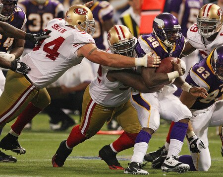 MINNEAPOLIS - SEPTEMBER 27: Adrian Peterson #28 of the Minnesota Vikings is tackled by Aubrayo Franklin #92 and Justin Smith #94 of the San Francisco 49ers at the Hubert H. Humphrey Metrodome on September 27, 2009 in Minneapolis, Minnesota. The Vikings defeated the 49ers 27-24. <br /><br /><span class="help">(Photo by Jonathan Daniel/Getty Images)</span>