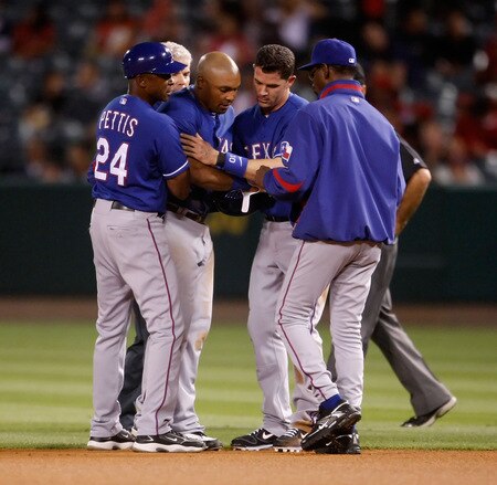 ANAHEIM, CA - SEPTEMBER 29:  (L-R) Coach Gary Pettis #24 of the Texas Rangers attends to Marlon Byrd #22 as Michael Young #10 and manager Ron Washington #38 offer a hand in the first inning against the Los Angeles Angels of Anaheim at Angel Stadium on September 29, 2009 in Anaheim, California.  <br /><br /><span class="help">(Photo by Jeff Gross/Getty Images)</span>