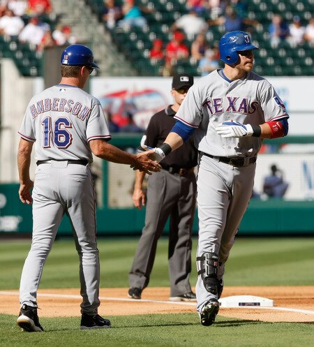 ANAHEIM, CA - OCTOBER 01:  Third base coach Dave Anderson #16 of the Texas Rangers congratulates Chris Davis #19 after hitting a two-run home run in the second inning against the Los Angeles Angels of Anaheim at Angel Stadium on October 1, 2009 in Anaheim, California. The Rangers defeated the Angels 11-3.  <br /><br /><span class="help">(Photo by Jeff Gross/Getty Images)</span>