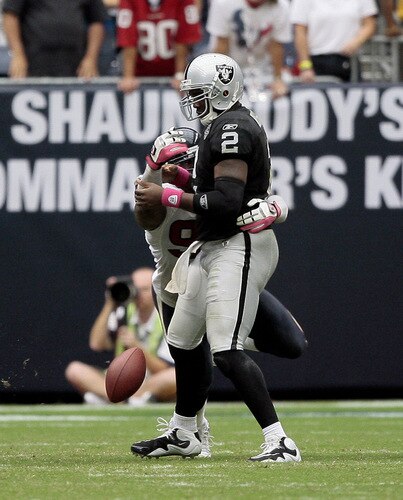 HOUSTON - OCTOBER 04:  Defensive end Mario Williams #90 of the Houston Texans knocks the ball loose from quarterback JaMarcus Russell #2 of the Oakland Raiders a fumble in the fourth quarter at Reliant Stadium on October 4, 2009 in Houston, Texas.  <br /><br /><span class="help">(Photo by Bob Levey/Getty Images)</span>