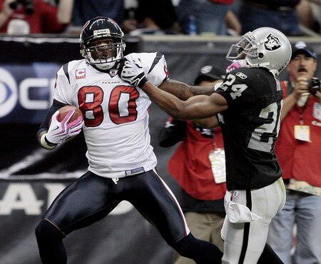 HOUSTON - OCTOBER 04:  Wide receiver Andre Johnson #80 of the Houston Texans gives safety Michael Huff #24 of the Oakland Raiders a stiff arm after making a 62 yard reception at Reliant Stadium on October 4, 2009 in Houston, Texas.  <br /><br /><span class="help">(Photo by Bob Levey/Getty Images)</span>