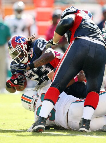 MIAMI - OCTOBER 04:  Running back Marshawn Lynch #23 of the Buffalo Bills is thrown for a loss by linebacker Cameron Wake #91 of the Miami Dolphins at Land Shark Stadium on October 4, 2009 in Miami, Florida.  <br /><br /><span class="help">(Photo by Doug Benc/Getty Images)</span>
