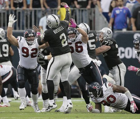 HOUSTON - OCTOBER 04:  Quarterback JeMarcus Russell #2 of the Oakland Raiders releases the ball  as he is pressured by linebacker Brian Cushing #56 and defensive tackle Jeff Zgonina #92 of the Houston Texans at Reliant Stadium on October 4, 2009 in Houston, Texas.  <br /><br /><span class="help">(Photo by Bob Levey/Getty Images)</span>