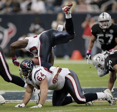 HOUSTON - OCTOBER 04:  Runnig back Steve Slaton #20 of the Houston Texans trips over guard Kasey Studdard #64 at Reliant Stadium on October 4, 2009 in Houston, Texas.  <br /><br /><span class="help">(Photo by Bob Levey/Getty Images)</span>
