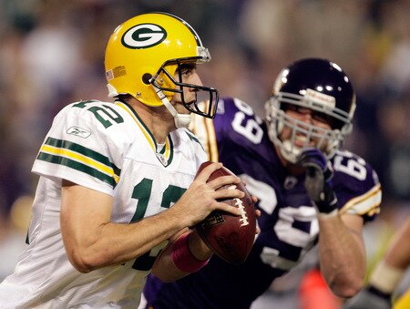 MINNEAPOLIS - OCTOBER 05:  Quarterback Aaron Rodgers #12 of the Green Bay Packers is chased by Jared Allen #69 of the Minnesota Vikings during the Monday Night Football game on October 5, 2009 at Hubert H. Humphrey Metrodome in Minneapolis, Minnesota.  <br /><br /><span class="help">(Photo by Jamie Squire/Getty Images)</span>