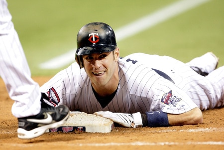 MINNEAPOLIS - OCTOBER 06:  Joe Mauer #7 of the Minnesota Twins dives back toward first after a single during the American League Tiebreaker game against the Detroit Tigers on October 6, 2009 at Hubert H. Humphrey Metrodome in Minneapolis, Minnesota.  <br /><br /><span class="help">(Photo by Jamie Squire/Getty Images)</span>