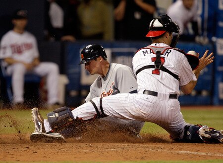 MINNEAPOLIS - OCTOBER 06:  Don Kelly #32 of the Detroit Tigers slides safely into home plate to score as Joe Mauer #7 of the Minnesota Twins applies the tag during the 10th inning of the American League Tiebreaker game on October 6, 2009 at Hubert H. Humphrey Metrodome in Minneapolis, Minnesota.  <br /><br /><span class="help">(Photo by Jamie Squire/Getty Images)</span>