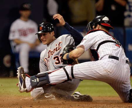 MINNEAPOLIS - OCTOBER 06:  Don Kelly #32 of the Detroit Tigers slides safely into home plate to score as Joe Mauer #7 of the Minnesota Twins applies the tag during the 10th inning of the American League Tiebreaker game on October 6, 2009 at Hubert H. Humphrey Metrodome in Minneapolis, Minnesota.  <br /><br /><span class="help">(Photo by Jamie Squire/Getty Images)</span>