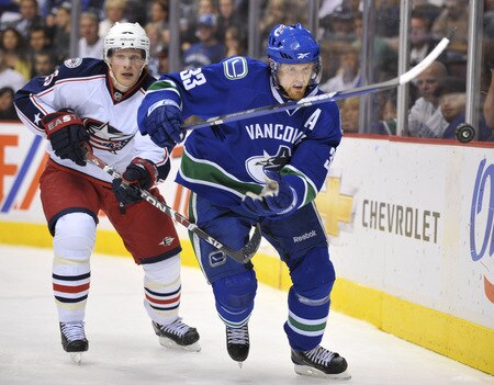 VANCOUVER, CANADA - OCTOBER 5:  Henrik Sedin #33 of the Vancouver Canucks keeps his eyes on the puck while being chased by Samuel Pahlsson #26 of the Columbus Blue Jackets during their game at General Motors Place October 5, 2009 in Vancouver, Canada.   <br /><br /><span class="help">(Photo by Nick Didlick/Getty Images)</span>