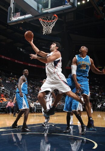 ATLANTA - OCTOBER 7: Zaza Pachulia #27 of the Atlanta Hawks puts up a shot against David West #30 of the New Orleans Hornets during a preseason game on October 7, 2009 at Philips Arena in Atlanta, Georgia.  <br /><br /><span class="help">(Photo by Scott Cunningham/NBAE via Getty Images)</span>