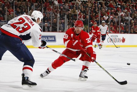 DETROIT - OCTOBER 10: Milan Jurcina #23 of the Washington Capitals gets a pass around the stick of Kris Draper #33 of the Detroit Red Wings on October 10, 2009 at Joe Louis Arena in Detroit, Michigan. <br /><br /><span class="help">(Photo by Gregory Shamus/Getty Images)</span>