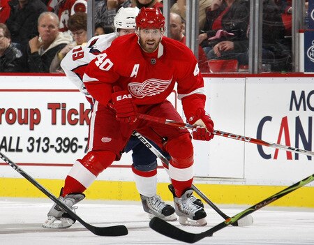 DETROIT - OCTOBER 10: Henrik Zetterberg #40 of the Detroit Red Wings tries to control the puck in front of Nicklas Backstrom #19 of the Washington Capitals on October 10, 2009 at Joe Louis Arena in Detroit, Michigan. <br /><br /><span class="help">(Photo by Gregory Shamus/Getty Images)</span>
