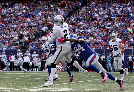 EAST RUTHERFORD, NJ - OCTOBER 11:  Mathias Kiwanuka #94 of the New York Giants forces a fumble against JaMarcus Russell #2 of the Oakland Raiders on October 11, 2009 at Giants Stadium in East Rutherford, New Jersey. The Giants defeated the Raiders 44-7.  <br /><br /><span class="help">(Photo by Jim McIsaac/Getty Images)</span>