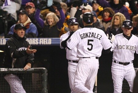 DENVER - OCTOBER 11:  Carlos Gonzalez #5 of the Colorado Rockies is congratulated after scoring against the Philadelphia Phillies in Game Three of the NLDS during the 2009 MLB Playoffs at Coors Field on October 11, 2009 in Denver, Colorado.  <br /><br /><span class="help">(Photo by Jed Jacobsohn/ Getty Images)</span>