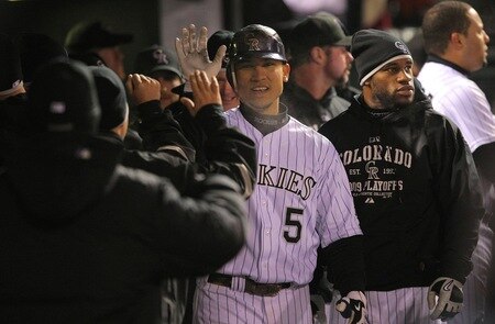 DENVER - OCTOBER 11:  Carlos Gonzalez #5 of the Colorado Rockies receives high fives in the dugout after hitting a game tying home run against the Philadelphia Phillies in the bottom of the fourth inning in Game Three of the NLDS during the 2009 MLB Playoffs at Coors Field on October 11, 2009 in Denver, Colorado.  <br /><br /><span class="help">(Photo by Doug Pensinger/ Getty Images)</span>