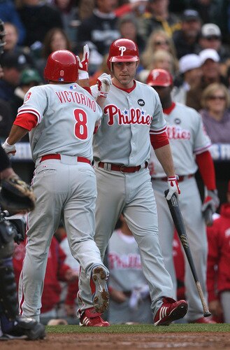 DENVER - OCTOBER 11:  Chase Utley #26 of the Philadelphia Phillies congratulates teammate Shane Victorino #8 affter Victorino's solo home run in the top of the first inning against the Colorado Rockies in Game Four of the NLDS during the 2009 MLB Playoffs at Coors Field on October 12, 2009 in Denver, Colorado. <br /><br /><span class="help">(Photo by Jed Jacobsohn/Getty Images)</span>