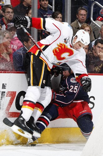 COLUMBUS, OH - OCTOBER 13: Adam Pardy #7 of the Calgary Flames lays a check on Jason Chimera #25 of the Columbus Blue Jackets on October 13, 2009 at Nationwide Arena in Columbus, Ohio.  <br /><br /><span class="help">(Photo by Gregory Shamus/Getty Images)</span>