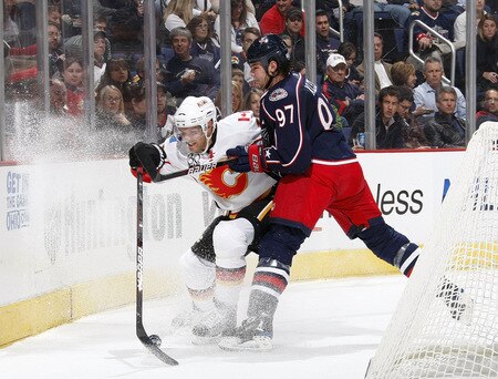 COLUMBUS, OH - OCTOBER 13: Fredrik Sjostrom #11 of the Calgary Flames tries to control the puck while taking a hit from Rostislav Klesla #97 of the Columbus Blue Jackets on October 13, 2009 at Nationwide Arena in Columbus, Ohio.  <br /><br /><span class="help">(Photo by Gregory Shamus/Getty Images)</span>