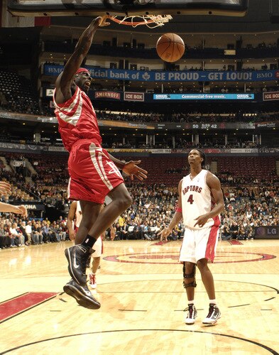 TORONTO - OCTOBER 15: Pops Mensah-Bonsu #21 of the Houston Rockets throws the hammer down in front of defender Chris Bosh #4 of Toronto Raptors during a game on October 15, 2009 at the Air Canada Centre in Toronto, Ontario, Canada.  <br /><br /><span class="help">(Photo by Ron Turenne/NBAE via Getty Images)</span>