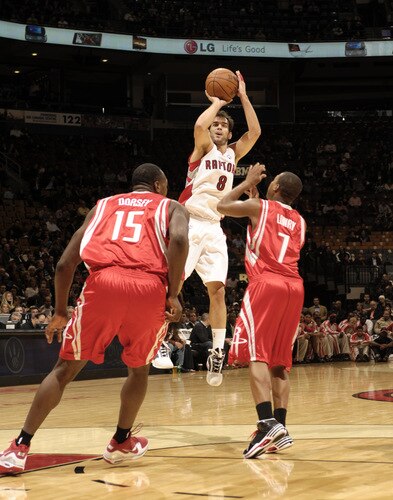 TORONTO - OCTOBER 15: Jose Calderon #8  of the Toronto Raptors takes a shot at the top of the key over defenders Carl Landry #7 and Joey Dorsey #15 of the Houston Rockets during a game on October 15, 2009 at the Air Canada Centre in Toronto, Ontario, Canada.  <br /><br /><span class="help">(Photo by Ron Turenne/NBAE via Getty Images)</span>