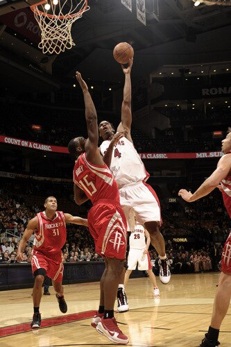 TORONTO - OCTOBER 15: Chris Bosh #4  of the Toronto Raptors drives the paint and tries to land the hookshot over Joey Dorsey #15 of the Houston Rockets during a game on October 15, 2009 at the Air Canada Centre in Toronto, Ontario, Canada.  <br /><br /><span class="help">(Photo by Ron Turenne/NBAE via Getty Images)</span>