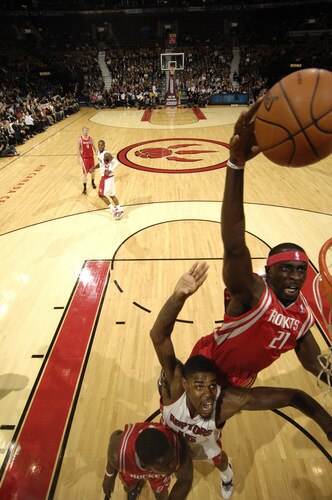 TORONTO - OCTOBER 15: Pops Mensah-Bonsu #21 of the Houston Rockets gets up high for the putback jam over the back of Amir Johnson #15 of Toronto Raptors during a game on October 15, 2009 at the Air Canada Centre in Toronto, Ontario, Canada.  <br /><br /><span class="help">(Photo by Ron Turenne/NBAE via Getty Images)</span>