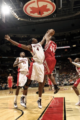 TORONTO - OCTOBER 15:  Chris Bosh #4 of the Toronto Raptors acts fast and gets his hands up to block the shot of Chuck Hayes #44 of the Houston Rockets during a game on October 15, 2009 at the Air Canada Centre in Toronto, Ontario, Canada.  <br /><br /><span class="help">(Photo by Ron Turenne/NBAE via Getty Images)</span>