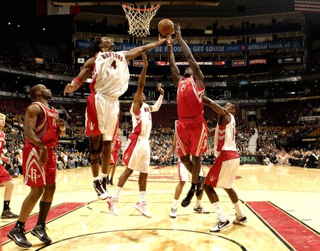 TORONTO - OCTOBER 15:  Chris Bosh #4 of the Toronto Raptors grabs the board just out of the reach of Pops Mensah-Bonsu #21 of the Houston Rockets during a game on October 15, 2009 at the Air Canada Centre in Toronto, Ontario, Canada.  <br /><br /><span class="help">(Photo by Ron Turenne/NBAE via Getty Images)</span>