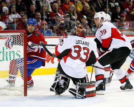 MONTREAL- OCTOBER 17:  Scott Gomez #91 of the Montreal Canadiens attempts to hjt the puck in mid-air behind Pascal Leclaire #33 of the Ottawa Senators during the NHL game on October 17, 2009 at the Bell Centre in Montreal, Quebec, Canada.  <br /><br /><span class="help">(Photo by Richard Wolowicz/Getty Images)</span>