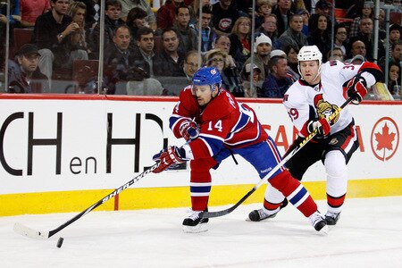 MONTREAL- OCTOBER 17:  Tomas Plekanec #14 of the Montreal Canadiens stick handles the puck in the corner while being defended by Matt Carkner #39 of the Ottawa Senators during the NHL game on October 17, 2009 at the Bell Centre in Montreal, Quebec, Canada.  <br /><br /><span class="help">(Photo by Richard Wolowicz/Getty Images)</span>
