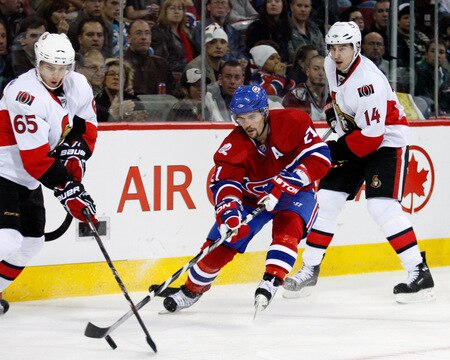 MONTREAL- OCTOBER 17:  Brian Gionta #21 of the Montreal Canadiens battles for the puck with Erik Karlsson #65 and of the Ottawa Senators during the NHL game on October 17, 2009 at the Bell Centre in Montreal, Quebec, Canada.  The Senators defeated the Canadiens 3-1.  <br /><br /><span class="help">(Photo by Richard Wolowicz/Getty Images)</span>