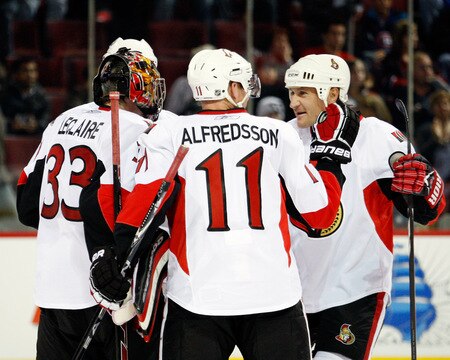 MONTREAL- OCTOBER 17:  Alexei Kovalev #27 celebrates the Ottawa Senators 3-1 victory over the Montreal Canadiens with Daniel Alfredsson #11 and Pascal Leclaire #33 during the NHL game against the Montreal Canadiens on October 17, 2009 at the Bell Centre in Montreal, Quebec, Canada.  The Senators defeated the Canadiens 3-1.  <br /><br /><span class="help">(Photo by Richard Wolowicz/Getty Images)</span>